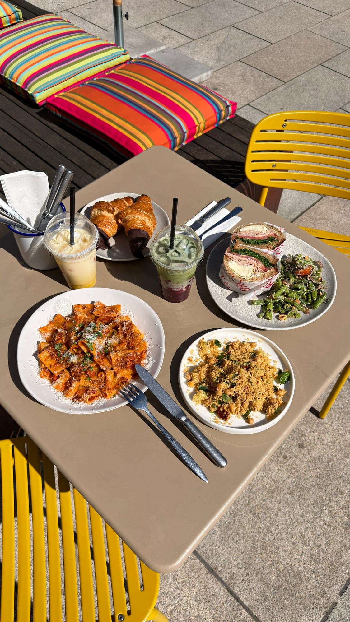 Mittagstisch mit Pasta, Couscous, Sandwich und Getränken
