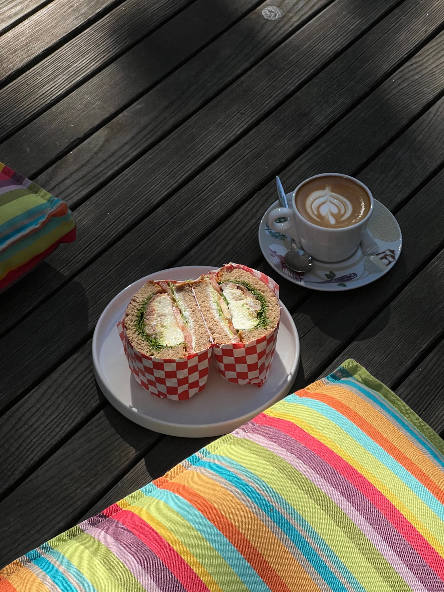 Sandwich und Cappuccino auf dem Holztisch