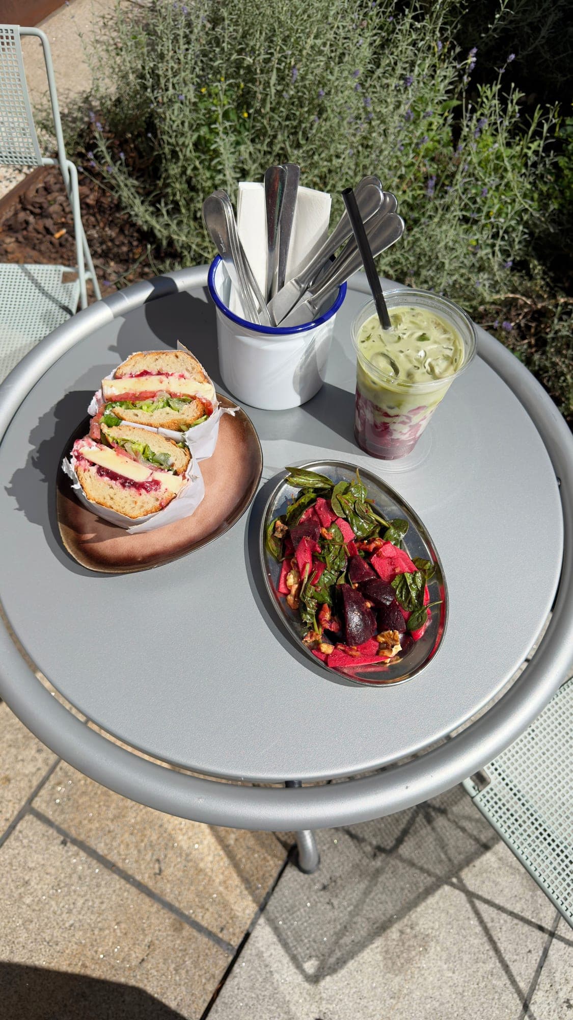 Sandwich, Rote-Bete-Salat und Matcha auf einem runden Tisch